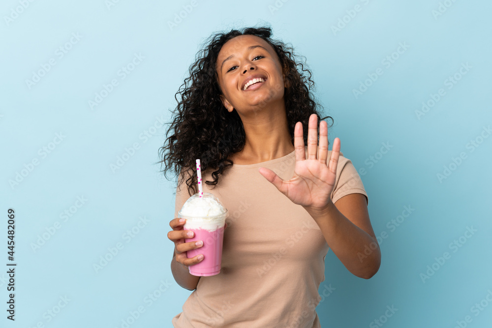 Teenager girl with strawberry milkshake isolated on blue background counting five with fingers Teenager girl with strawberry milkshake isolated on blue background counting five with fingers