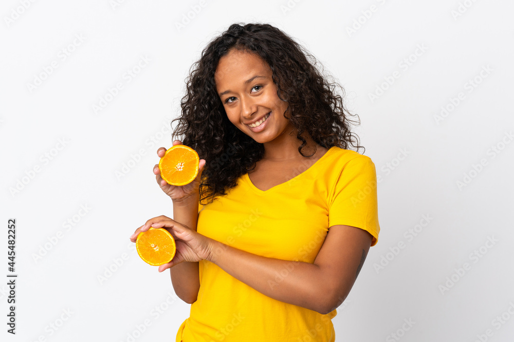 Teenager cuban girl isolated on white background holding an orange Teenager cuban girl isolated on white background holding an orange