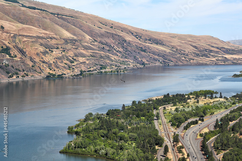 The I-84 winds its way along the Columbia River Gorge in Oregon. In the very center of the photo, a bald eagle can be seen chasing off a crow. photo