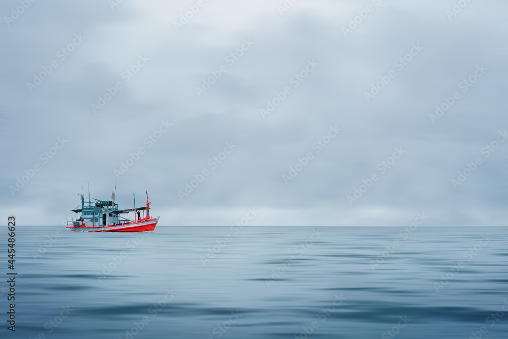 fishing boat floating in sea during strom coming with cloudy sky