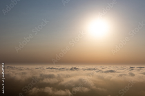 Aerial sunset view over the cloud facing the sun. Scenic view above the clouds