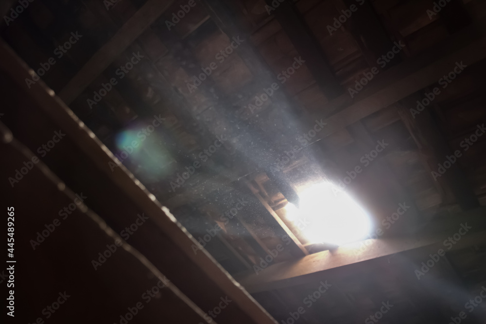 Broken wooden ceiling casting sunlight through a hole. Broken wooden ceiling casting sunlight through a hole.