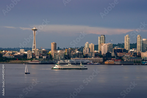 A sailboat and Washington State Ferry boat sail on Puget Sound as the famous Space Needle and skyscrapers rise above Elliott Bay in Seattle.