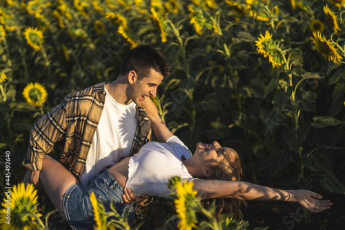 Closeup shot of a Caucasian lovely couple at the sunflowers field inSpain photo