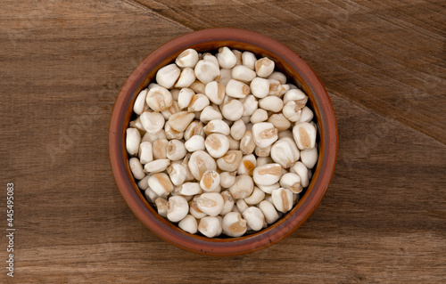Top view of bowl with white corn for cooking on wooden table background