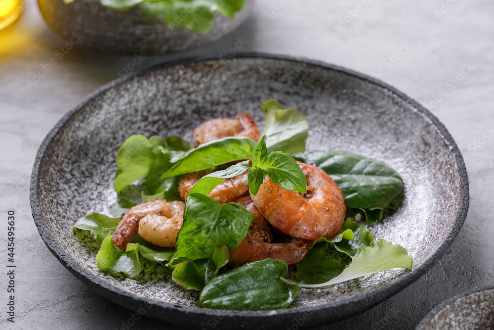 Fresh green salad with basil leaves, fried shrimps and lemon. Close up dish with copy space. Top view Fresh green salad with basil leaves, fried shrimps and lemon. Close up dish with copy space. Top view