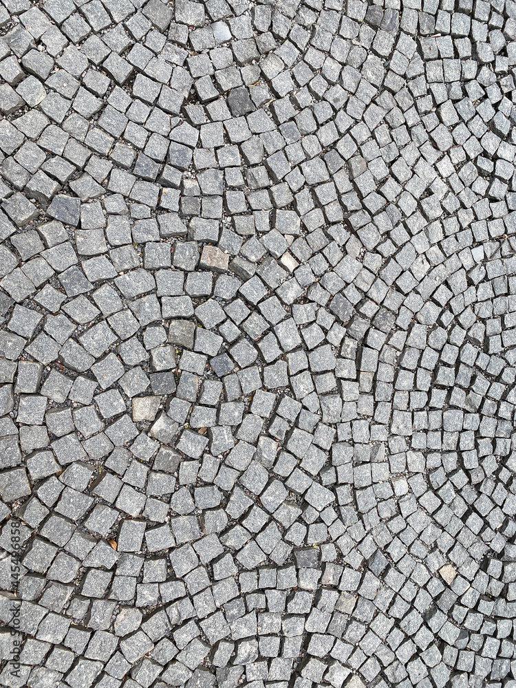 sidewalk, radially paved with small square granite stones. radial pattern. top view. sidewalk, radially paved with small square granite stones. radial pattern. top view.