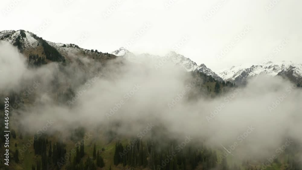 Aerial flight through clouds over mountain landscape Aerial flight through clouds over mountain landscape