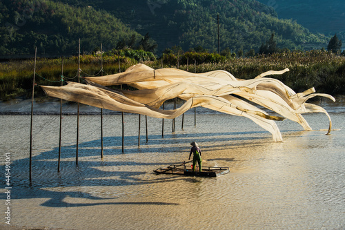 Xiapu fisherman - XIAPU, CHINA – DEC 08, 2019: A fisherman hangs giant fishing nets to dry in Xiapu, China's Fujian province