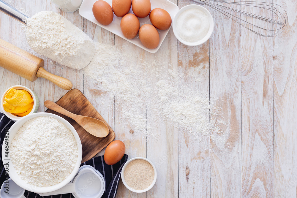 Homemade dough recipe (eggs, flour, milk, sugar) on a wooden table top view. Homemade dough recipe (eggs, flour, milk, sugar) on a wooden table top view.