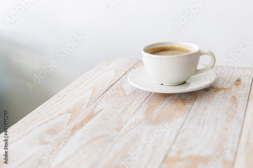 white coffee cup on wooden table with morning light
