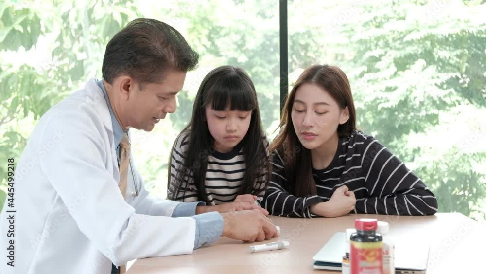 Asian male doctor health consultation. Blood sugar test to check for diabetes in women who are mothers in the parent clinic for medical treatment with children her daughter nearby with care. Asian male doctor health consultation. Blood sugar test to check for diabetes in women who are mothers in the parent clinic for medical treatment with children her daughter nearby with care.