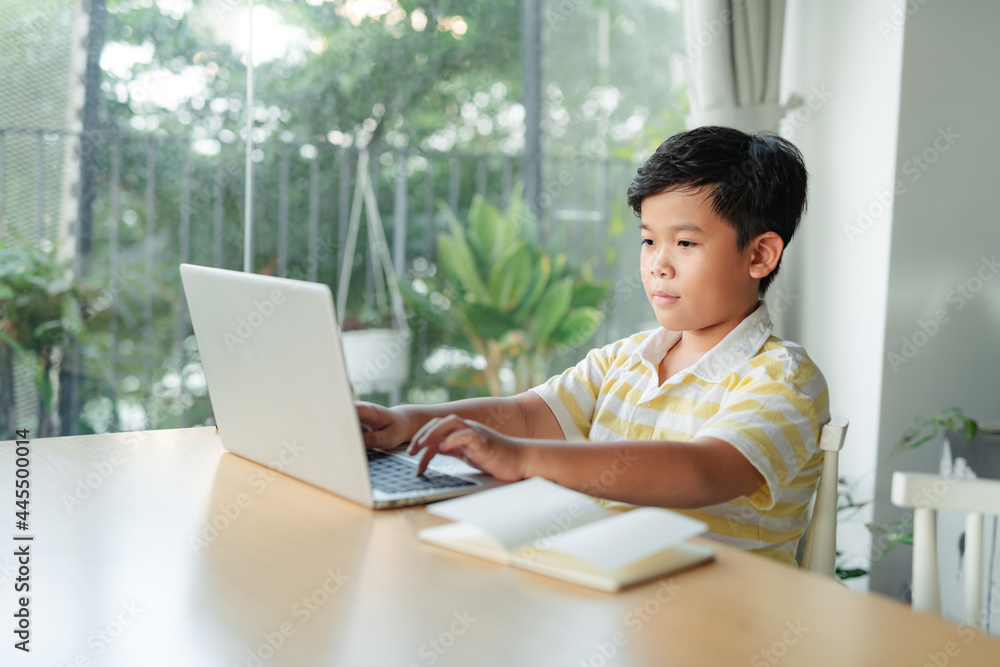 Little boy using laptop studying math during his online lesson at home Little boy using laptop studying math during his online lesson at home