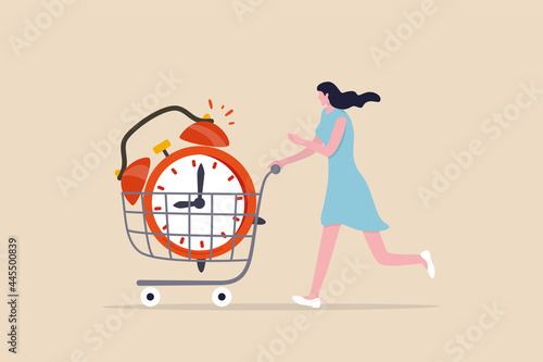 Buying time to delay or gain more time to do something, time is money, young adult woman buying time with big alarm clock in shopping cart trolley.