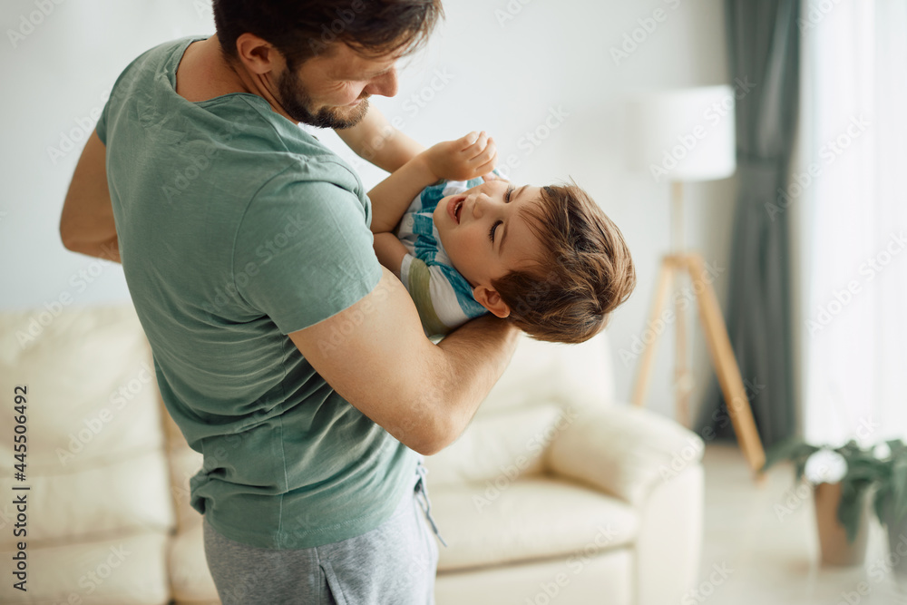 Carefree father and son have fun while playing at home. Carefree father and son have fun while playing at home.