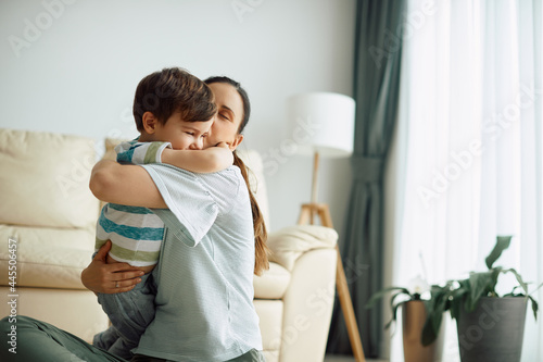 Canvastavla Loving mother hugs and kisses her small son at home.