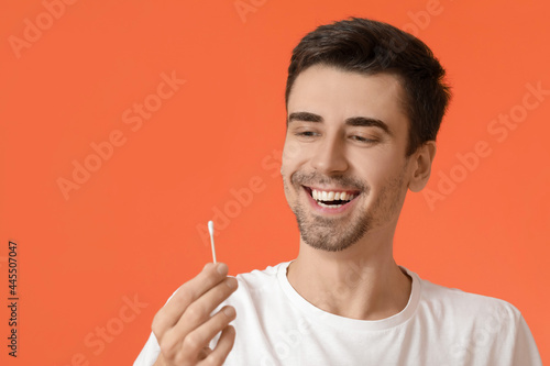 Young man with cotton bud o...