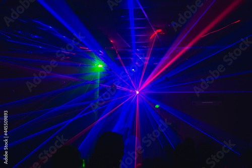 A blurry background of blue laser beams in the dark at a disco