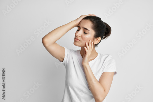 woman in white t-shirt emotion displeasure headache health problems