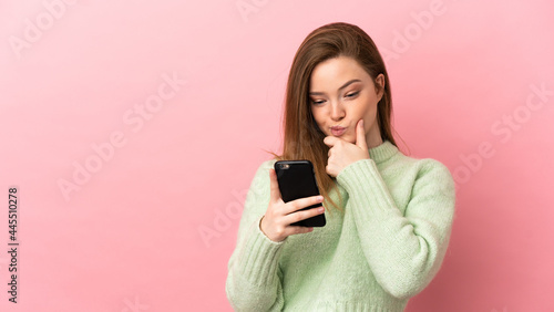 Teenager girl over isolated pink background thinking and sending a message