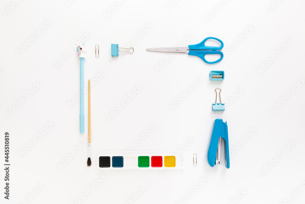 Top view of modern white blue office desktop with school supplies and stationery on table around empty space for text. Back to school concept flat lay with mockup Top view of modern white blue office desktop with school supplies and stationery on table around empty space for text. Back to school concept flat lay with mockup