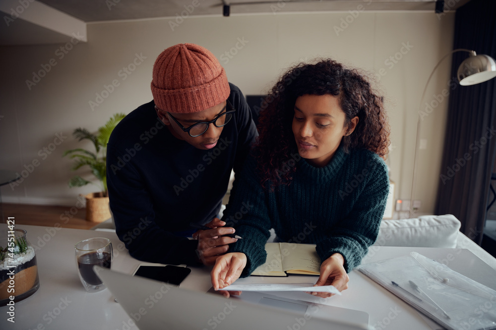 Close up of mixed race couple using laptop for online banking. Happy African American couple working remotely from home. High quality photo Close up of mixed race couple using laptop for online banking. Happy African American couple working remotely from home. High quality photo