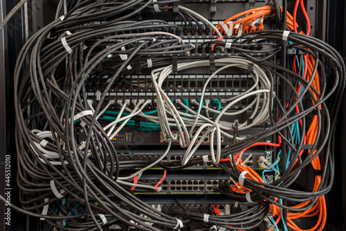 Working servers, switches or routers in data center with a lot of cables in a mess and clutter