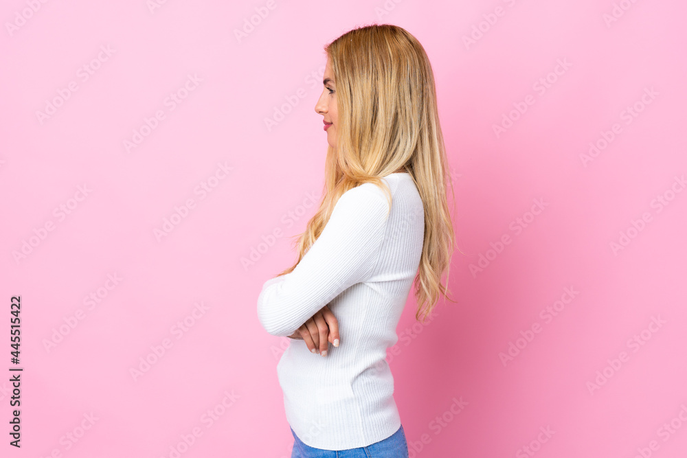 Young Uruguayan blonde woman over isolated pink background in lateral position Young Uruguayan blonde woman over isolated pink background in lateral position