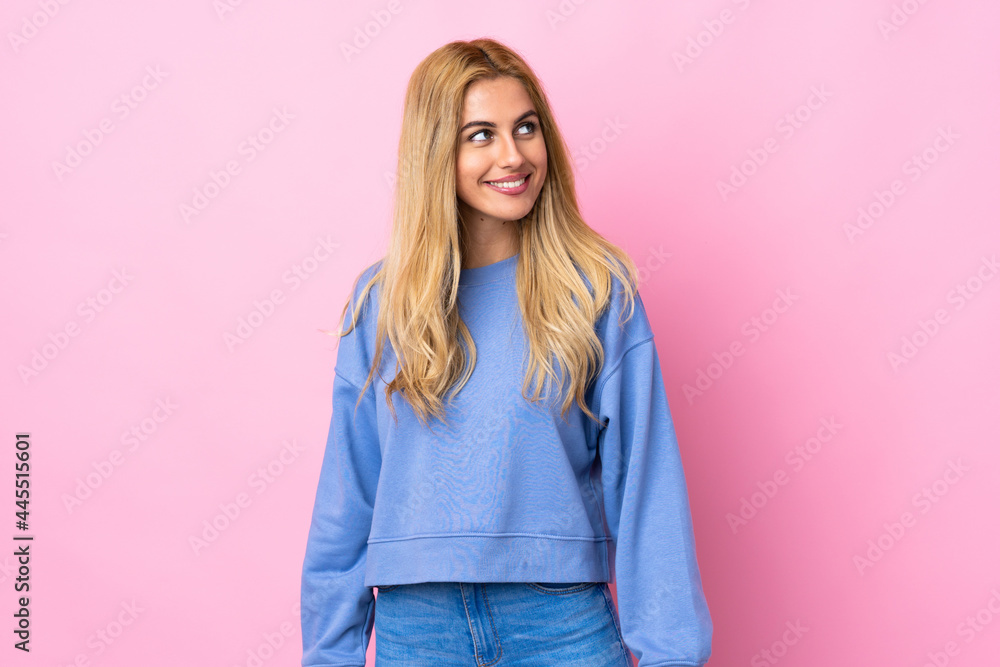 Young Uruguayan blonde woman over isolated pink background thinking an idea while looking up Young Uruguayan blonde woman over isolated pink background thinking an idea while looking up