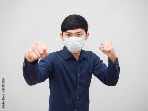 Asian man wearing protect mask stance and punch serious face on white background