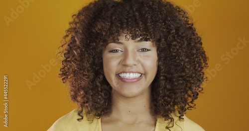 Beautiful brunette model smiling at camera. Beautiful teeth. Curly hair. Brazilian young woman.