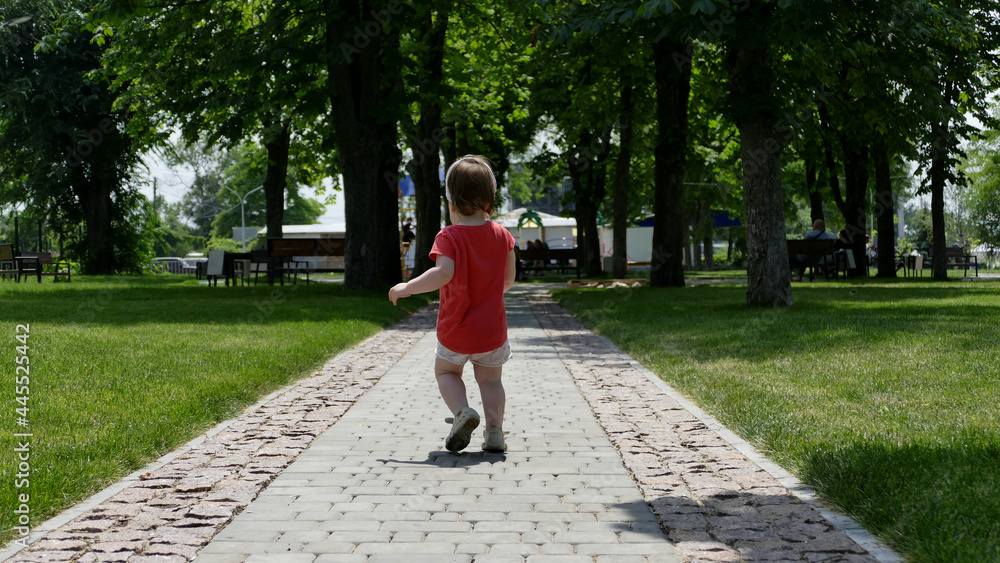 Little Girl In Walks On Stone Path In Green Park