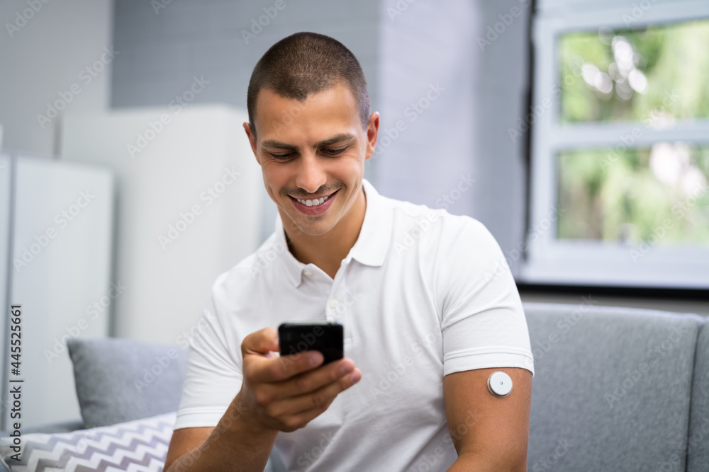 Man Using Continuous Glucose Remote Monitor Man Using Continuous Glucose Remote Monitor