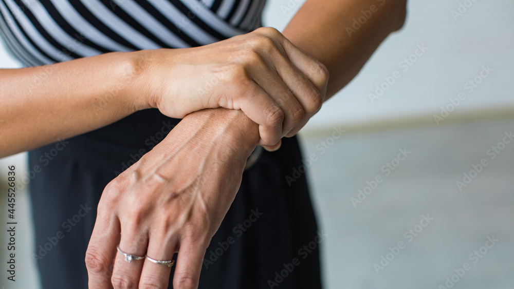 Woman shows hand and hold wrist with feeling pain, suffer, hurt and tingling. Concept of