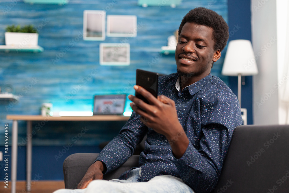 Black man greeting colleagues on video call conference in living room. Working from home african american remote worker in distance communication chat, learning about business project Black man greeting colleagues on video call conference in living room. Working from home african american remote worker in distance communication chat, learning about business project