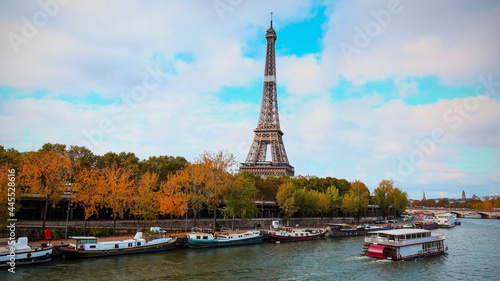Romantic view in Autumn season with Eiffel Tower and boats on Seine river in Paris, France.