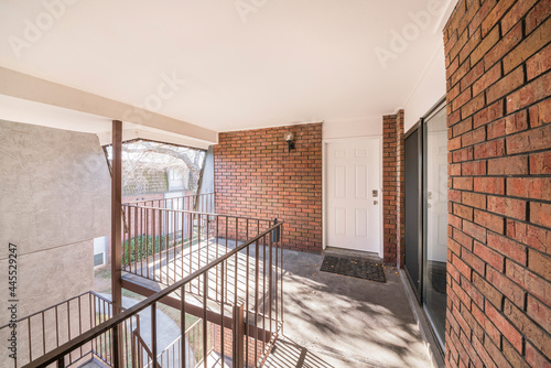 Front door of a second floor apartment with veranda