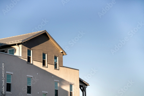 Low angle view of a two-storey house building against the clear blue sky © Jason