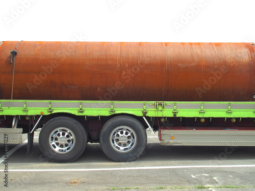 トラックの荷台に積まれた錆びた大きな鋼管 photo