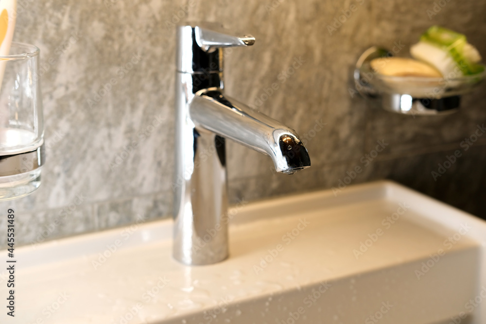 water pours a thin stream from a chrome plated faucet, bathroom interior, the concept of a healthy lifestyle, cleanliness, health, treatment, save water resources water pours a thin stream from a chrome plated faucet, bathroom interior, the concept of a healthy lifestyle, cleanliness, health, treatment, save water resources