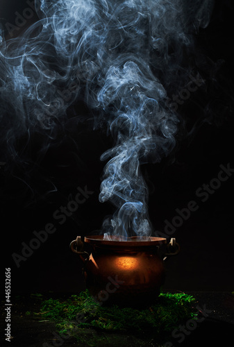The witch's smoking cauldron on dark background.