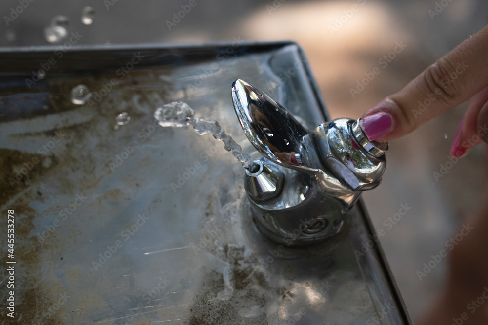 dedo pulsando fuente con agua levitando