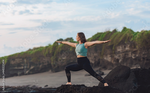 Girl doing yoga by the sea.