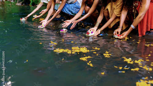  Hands of girls let flowers in the water photo