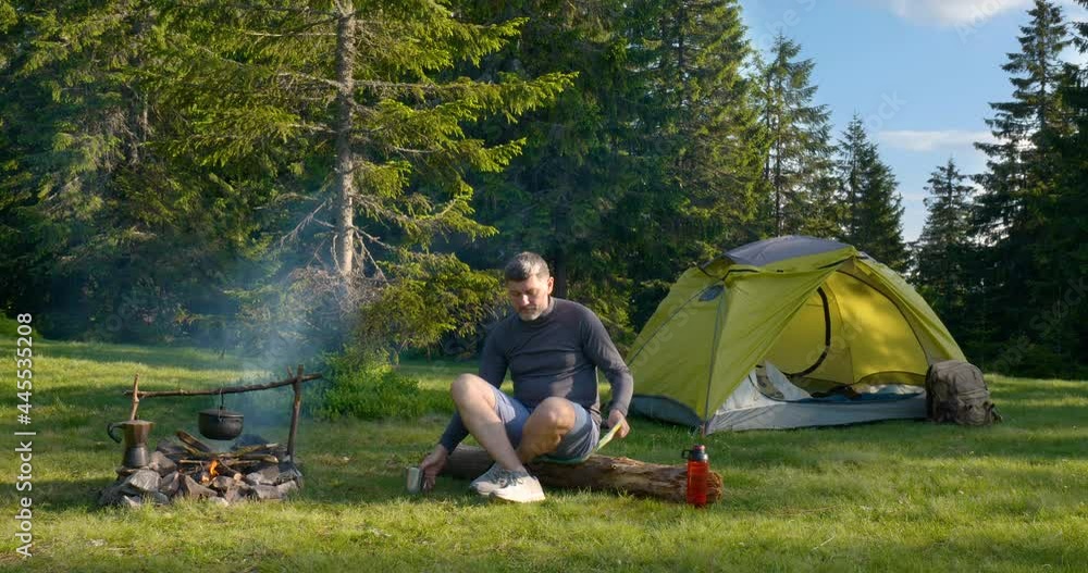 The man drinks tea and looks at the map in the Camping. The man drinks tea and looks at the map in the Camping.