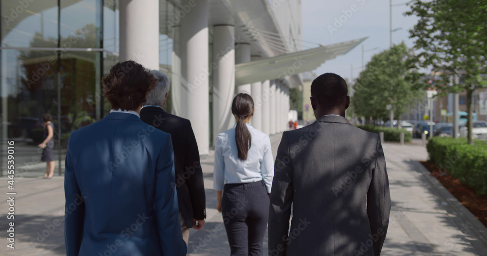 Back view of multiethnic entrepreneurs walk to business meeting outdoors Back view of multiethnic entrepreneurs walk to business meeting outdoors