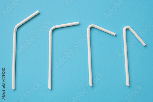 Biodegradable eco friendly white paper drinking straw on blue background photo
