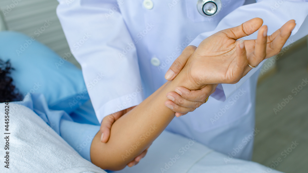 Doctor hold hand of patient on bed in hospital and checkup nervous system for cure and treatment. Concept of Guillain barre syndrome and numb hands disease or vaccine side effect Doctor hold hand of patient on bed in hospital and checkup nervous system for cure and treatment. Concept of Guillain barre syndrome and numb hands disease or vaccine side effect