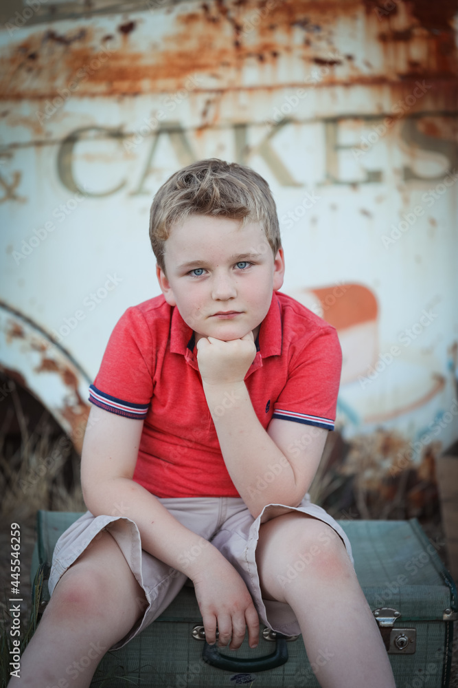 Beautiful portrait image of young caucasian boy sitting with chin resting on hand