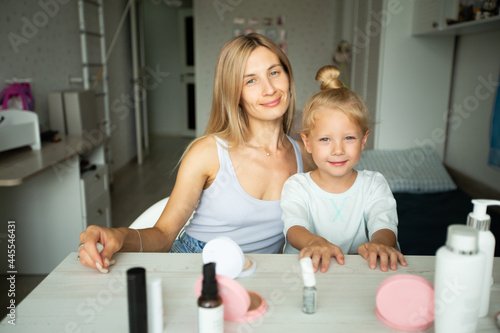 mom and beautiful little daughter at the table at home 